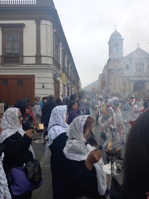 Foto de una procesión en Lima con humo de incienso y mujeres con velo.