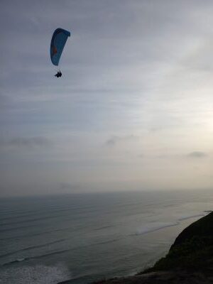 Foto de un parapente sobrevolando el malecón de Lima.