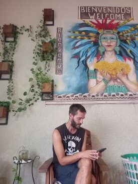 Foto de Josu mirando su móvil en la entrada de nuestro hostal de Mérida, México.