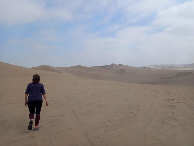 Foto mía caminando en el desierto de Ica, entre las dunas.