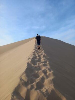Josu caminando por el filo de la duna gigante de Huacachina.